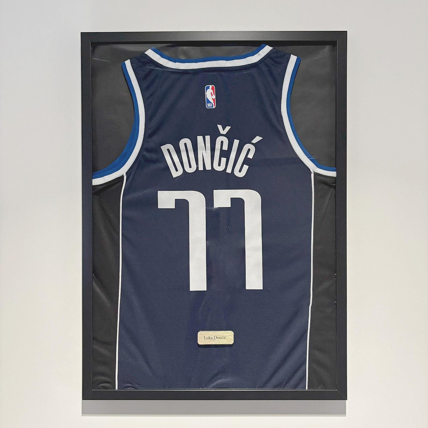 a framed jersey hangs on a wall