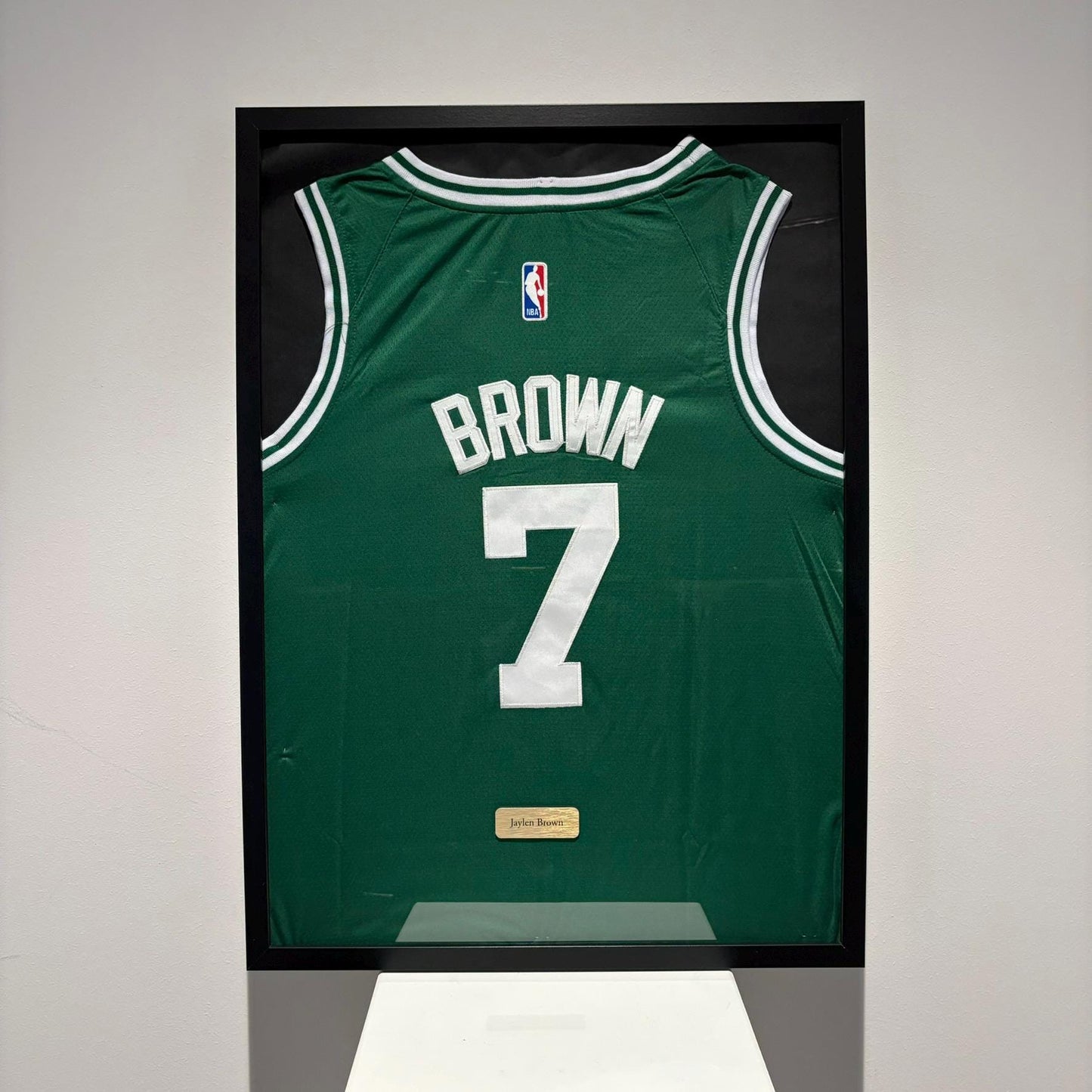 a basketball jersey is hanging on a wall