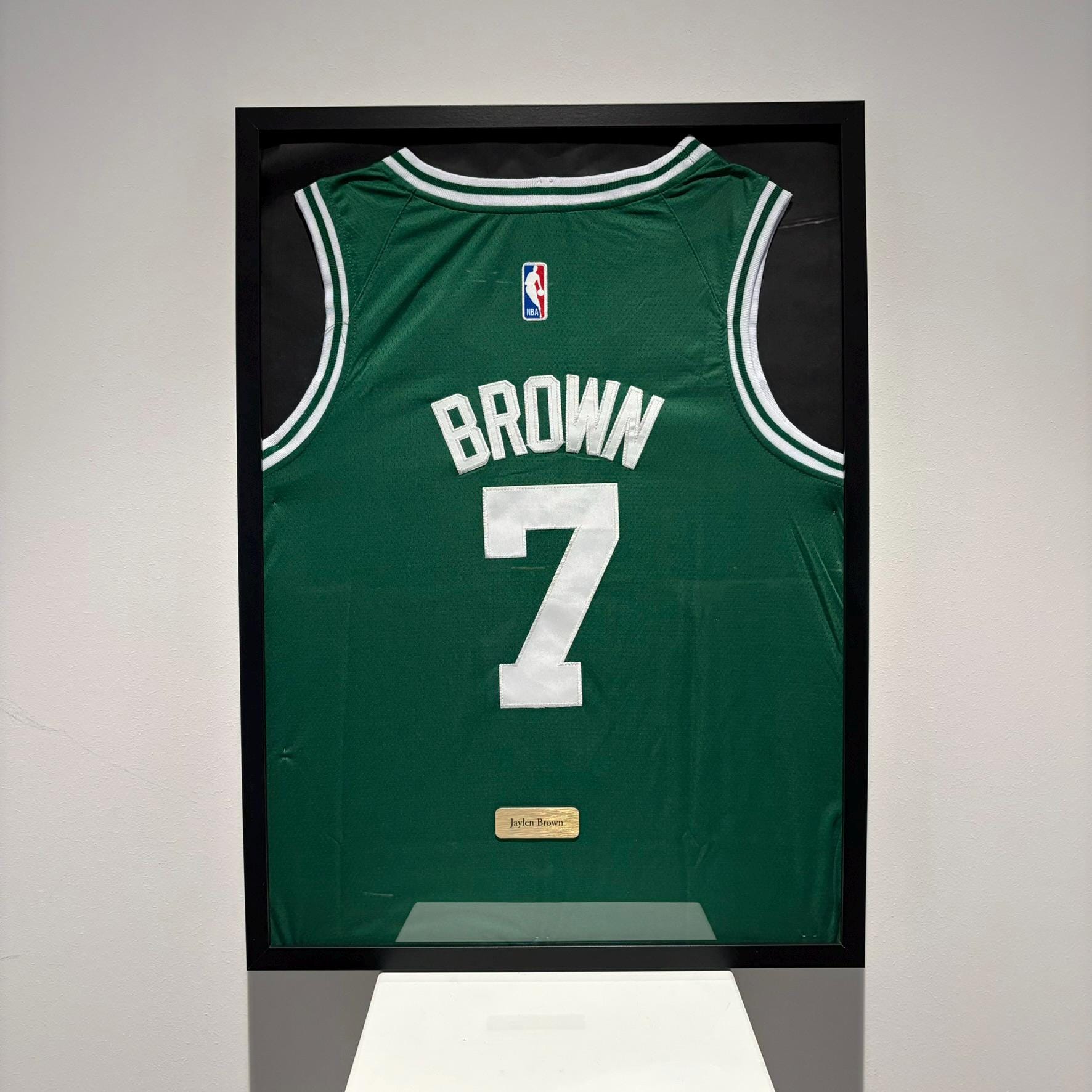 a basketball jersey is hanging on a wall